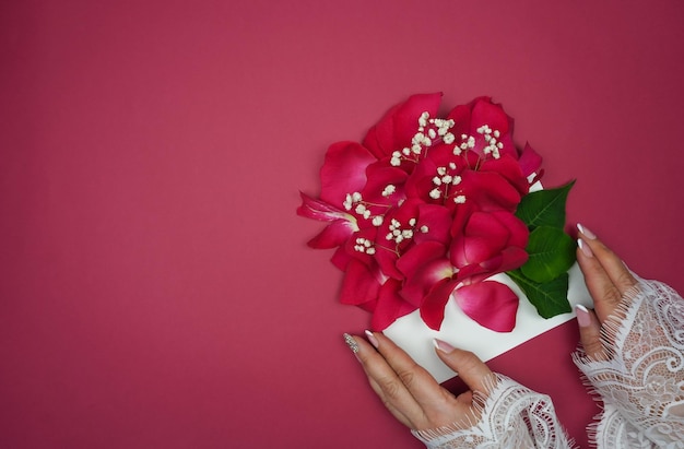 Women's hands hold an envelope with rose petals