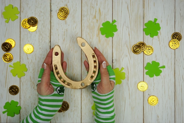 Women's Hands Hold a golden Horseshoe on St. Patrick's Day