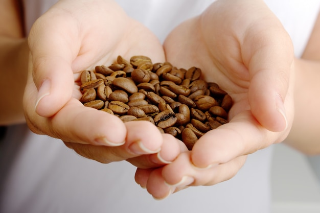 Women's hands holding coffee beans