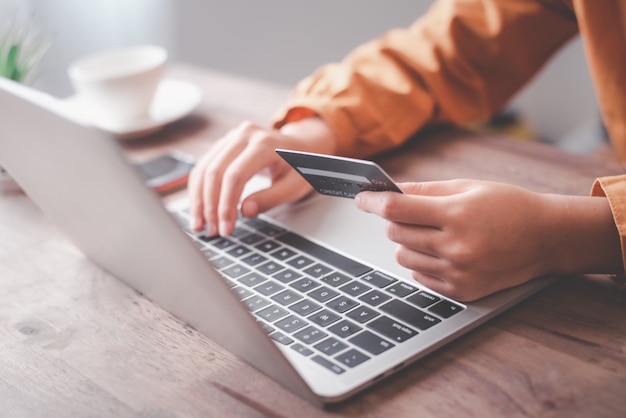 Women's hands holding a credit card and work on laptop Online payment for online shopping