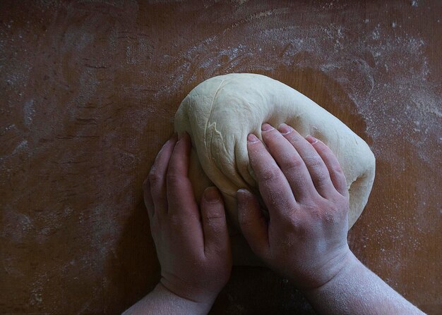 Women's hands knead the dough