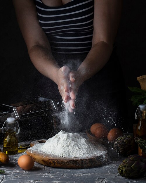 Women's hands making pasta dark rustic style