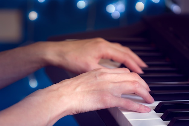 Women's hands playing the piano