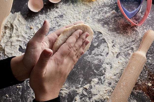 Women's hands roll out the dough