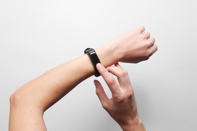 Women's hands use smart watch on gray table. Modern gadgets, top view