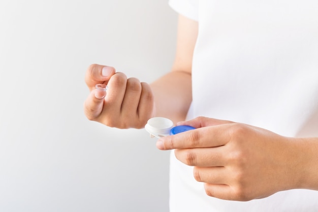 Women's hands with contact lenses and a container for lenses