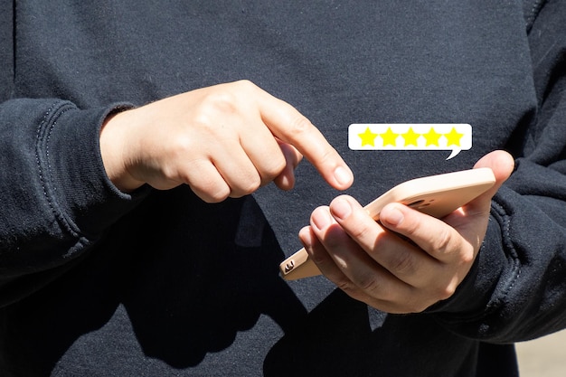 Women's hands with a phone product quality rating five stars closeup