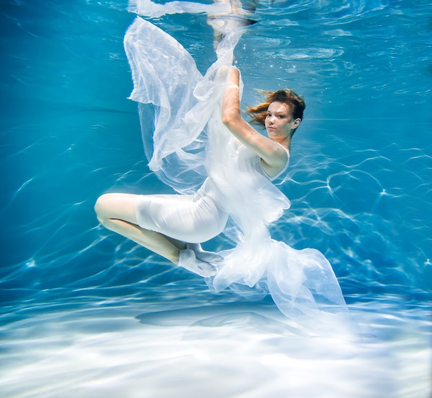 Women's health concept. Girl underwater in white. lightness, freshness and health