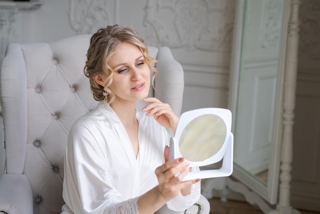 Women's skin care Caucasian woman touches her face and looks in mirror