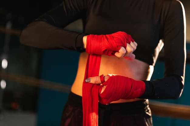 Women self defense girl power woman fighter preparing for fight wrapping hands with red boxing wraps