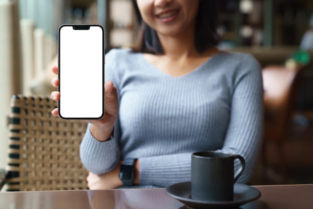 Women sit back and relax in the hotel restaurant feeling happy showing phone white blank screen