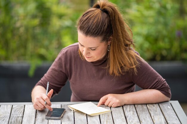 Photo women teacher writing outside wprking writing notes