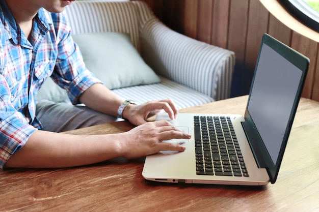 Women touching screen and man typing laptop on wood table