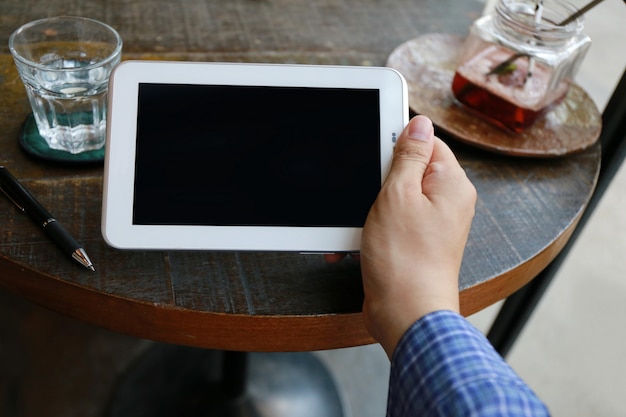 Women touching screen and man typing laptop on wood table