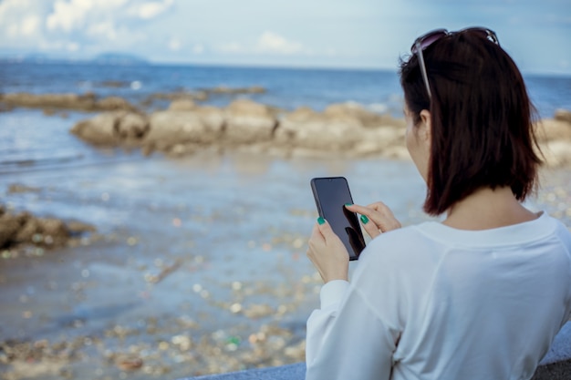 Women use smartphone on hand outdoor.