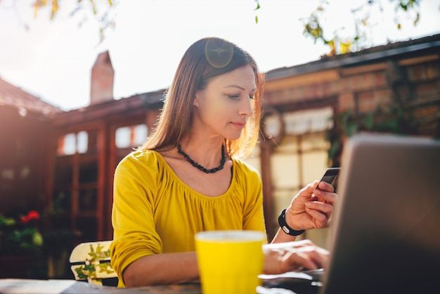 Women using credit card at backyard patio