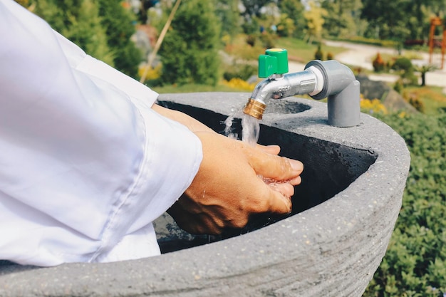 Photo women washing hands with nature background under the sunlight hygiene concept hand detail