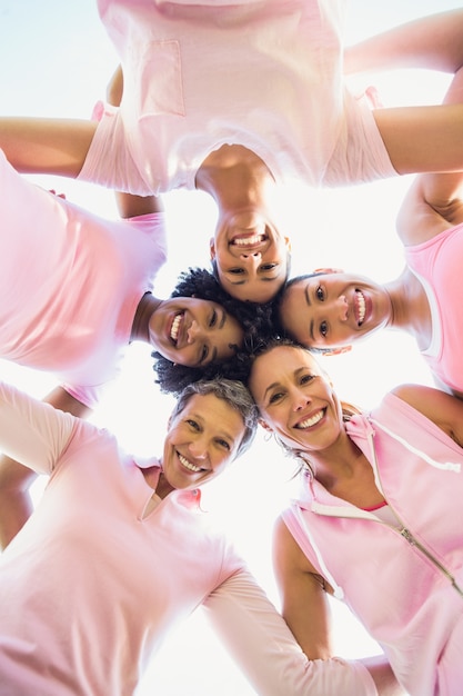 Women wearing pink for breast cancer with arms around