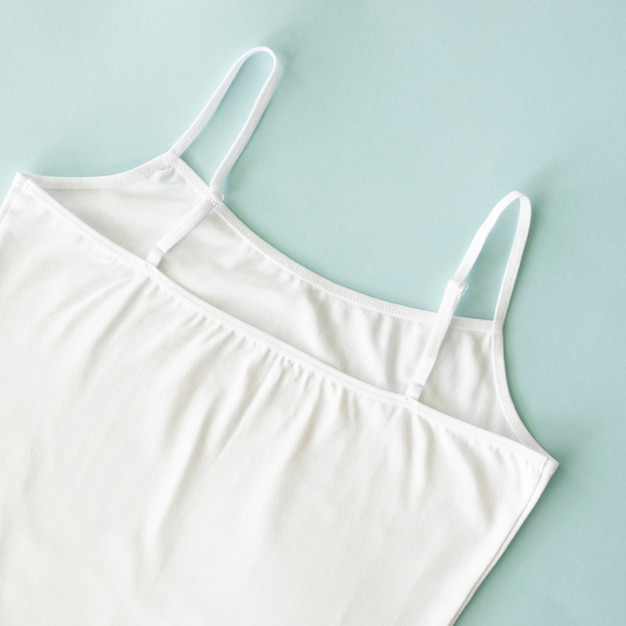 Women white singlet undershirt tank top isolated on blue natural cotton and casual underwear concept