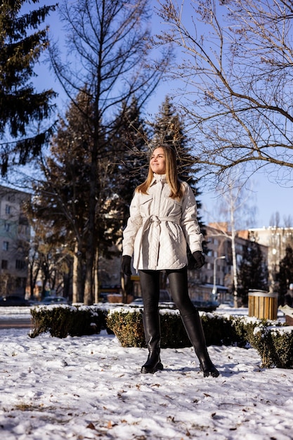 Women in white winter coats and black leather boots Street style casual women's fashion Winter women's style