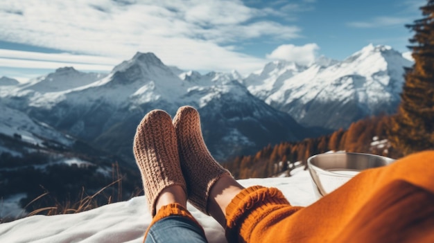 Women39s feet in cozy warm wool socks against the backdrop of the high snowy mountains of the Alps and the blue sky The concept of winter holidays Travel Vacations in Nature