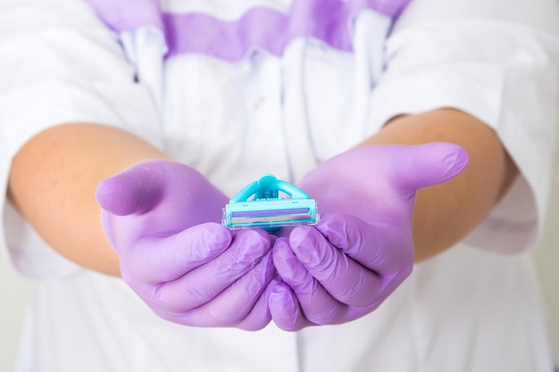 Women39s hands hold two shaving razor for epilation on a blue background