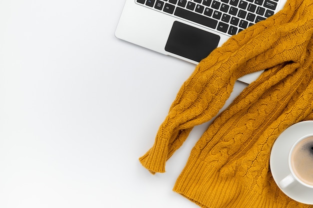 Womens autumn orange sweaters, laptop and coffee cup on white wooden background