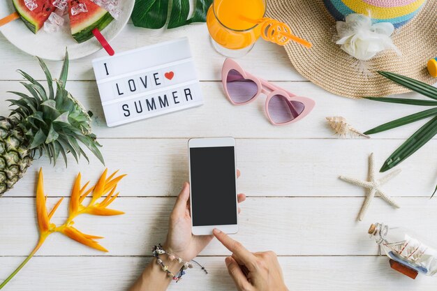 Photo womens casual clothes with accessories items and tropical fruits and flowers on white wooden background summer concept wtih smart phone and copy space