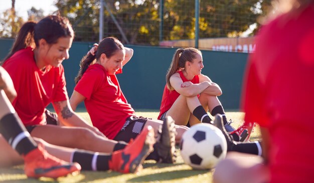 Womens Football Team Stretching Whilst Training for Soccer Match