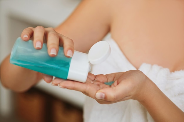 Womens hands hold tonic to remove makeup