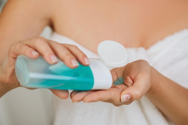 Womens hands hold tonic to remove makeup