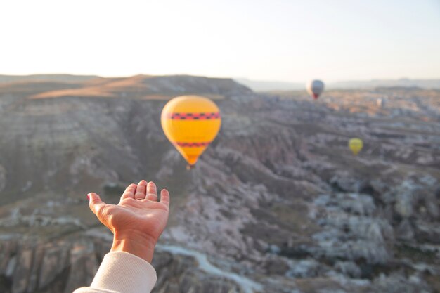 Womens hands in the shape of a heart against the background of flying balloons in the sky of Cappadocia Holidays in Turkey travel during a pandemic