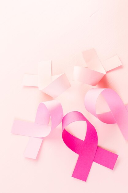 Womens health symbol in pink ribbon on a pink background.