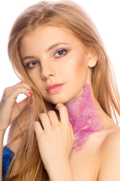 Wonderful blonde model with glitter makeup posing at studio over a white background