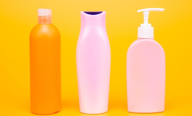 Wonderful daily necessities for you. Plastic packaging bottles. Cosmetic bottles yellow background. Toiletry packing. Liquid containers. For bath and shower products, copy space.