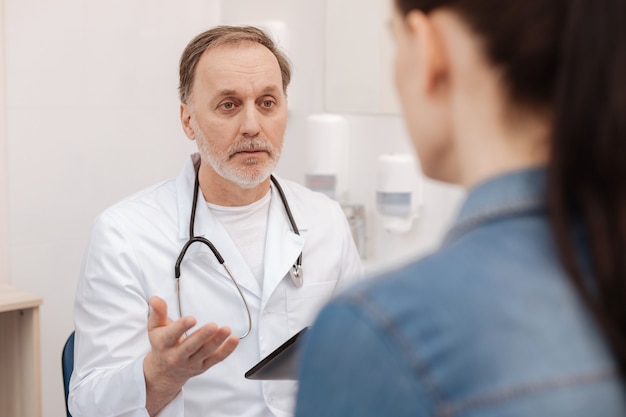 Wonderful friendly experienced cardiologist having an open conversation with young woman about her diagnosis while figuring out the ways of treating that disease