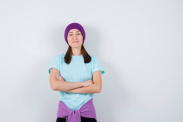 Wonderful lady with hands crossed in blouse, beanie and looking confident . front view.