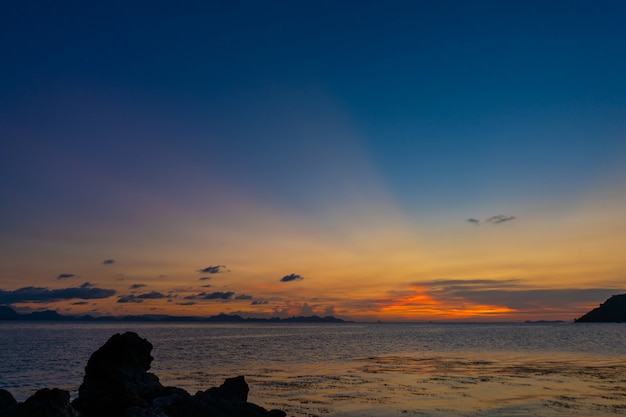 Wonderful sunset landscape on the seashore, colors of the sunset sky and silhouette of island in the water. incredible tropical sunset