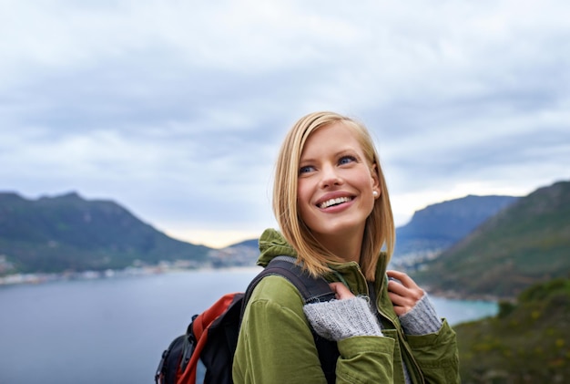 In wonderment of nature A young woman looking over her shoulder and enjoying the beauty of nature