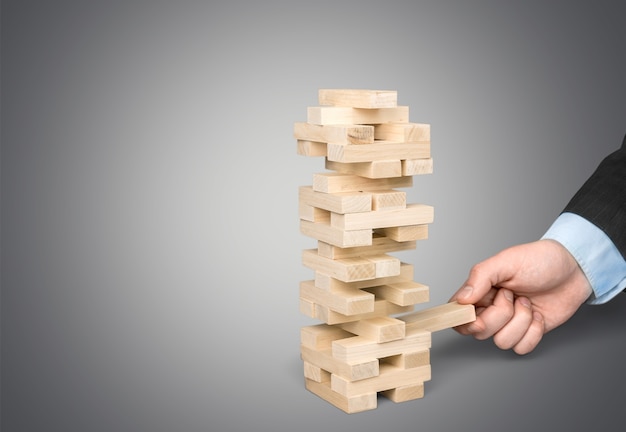 Wood blocks stack game with Hand on background,Conceptual of Teamwork, Strategy and Vision.