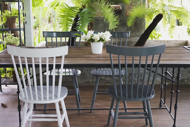 Wood chair and flowerpot on table near garden