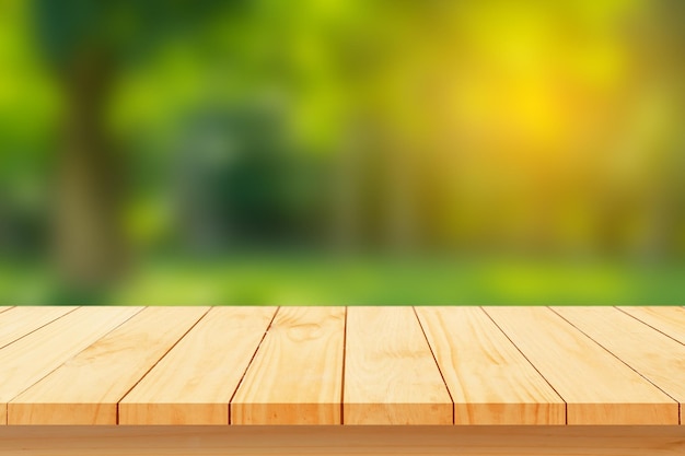 Wood floor with blurred trees of nature park background and summer season product display montage