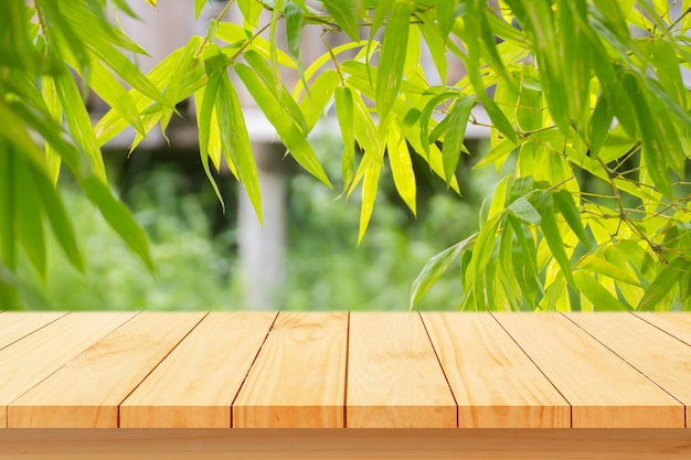 Wood floor with blurred trees of nature park background and summer season product display montage