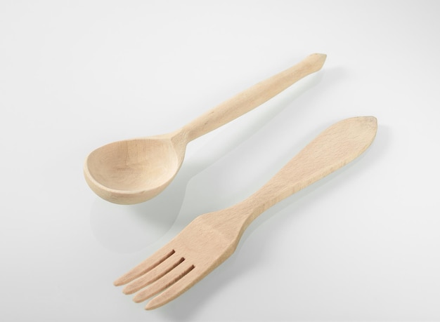 Wood kitchen utensils Wooden spoon and fork on a white mirror background