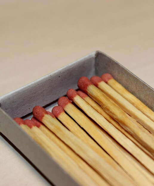 Photo wood matchsticks with red sulfur heads in a paper matchbox macro shot photo