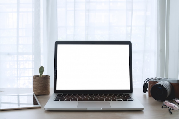 Photo wood office table with blank screen laptop on white curtain backdrop texture background.