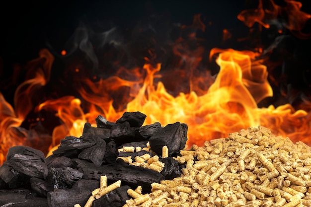 wood pellets and pieces of coal with flames in the background