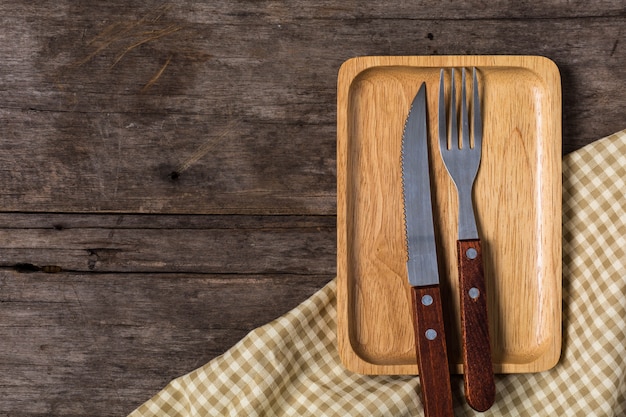 Wood plate with Steak knife on wooden background