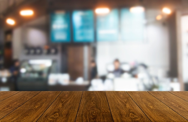 Wood table in blurry background of modern restaurant room or coffee shop for product display mockup.