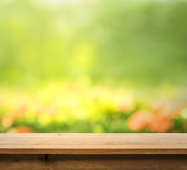 Wood table top on blur abstract green from garden in the morning